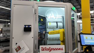 A robotic arm fills prescriptions at a Walgreens’ micro-fulfillment center.